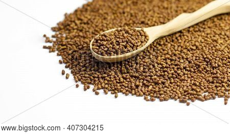 Buckwheat Tea In A Wooden Spoon On A White Background. Isolate. Buckwheat Tea Close-up Macro Photogr
