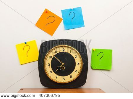 colorful paper note and text question mark on the wall clock
