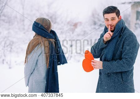 Handsome Elegant Man, Finger To Mouth - Tsss Gesture, Surprise For His Girlfriend Holding Red Heart,