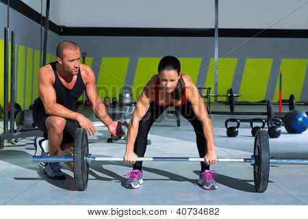 Turnhalle Personaltrainer Mann mit Gewichtheben bar weiblich Workout in Übung