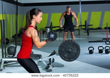 Mädchen Hantel und Mann Gewichtheben Bar Workout im Fitness-Studio