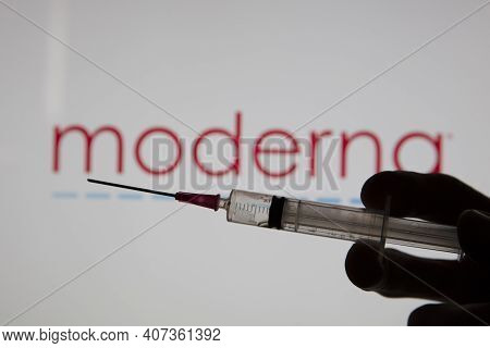 Oxford, Uk - February 2020: A Covid Vaccine Syringe Against The Moderna Logo