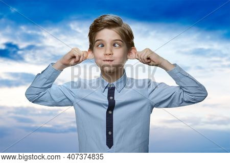 Caucasian Little Boy Is Fooling Around. Cute Boy In Shirt Is Puffing Out His Cheeks And Stratching E