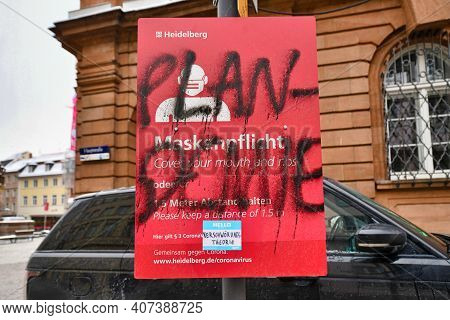 Heidelberg, Germany - February 2021:  Word 'plandemic' In German Written Over Signs For Face Mask An