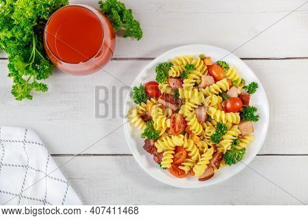 Rotini Pasta, Ham And Vegetables With Glass Of Tomato Juice. Balanced Meal