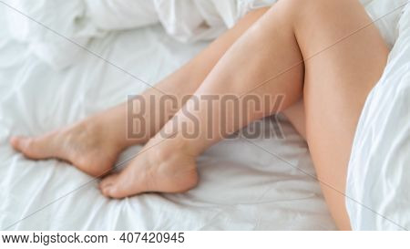 Slim, Perfect And Beautiful Crossed Woman Legs On Bed. Cropped Image Of Erotically Lying On Bed Beau