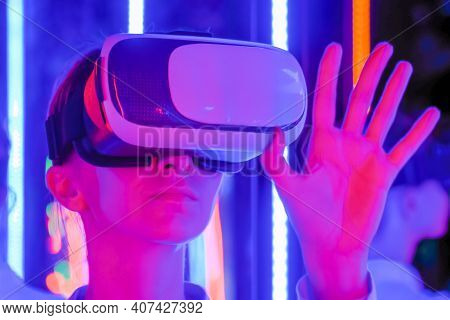 Woman Using Virtual Reality Headset And Moving Hand At Interactive Technology Exhibition With Colorf