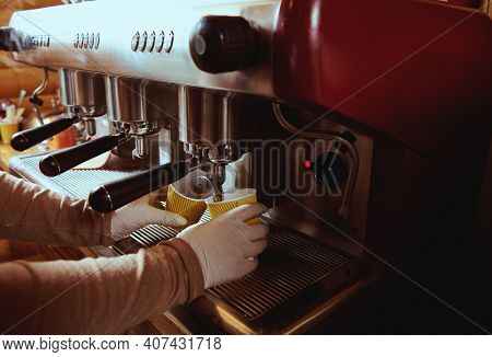 Coffee Machine Pourig Coffee To Yellow Cardboard Coffee Cup In Bar. Cropped Image. Closeup