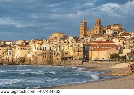 Cefalu cityscape at sunset in province of Palermo, Sicily, Italy. Medieval sicilian town Cefalu. Old town Cefalu and Cathedral Basilica in sunset light