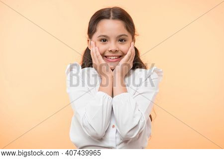 Full Of Excitement. Girl Happy Smiling Face Touches Her Cheeks Yellow Background. Schoolgirl Can Not