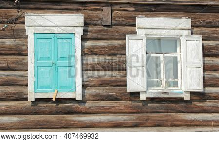 Two Windows With White Wooden Shutters On The Background Of A Log Wall