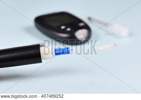 Close Up Of Needle Of Lancing Device For Diabetes Treatment With Blood Glucose Sugar Meter And Syrin
