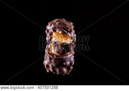 Chocolate Candy With Caramel And Nuts. Broken Candy Into Pieces. Stretching Caramel. Chocolate Candy