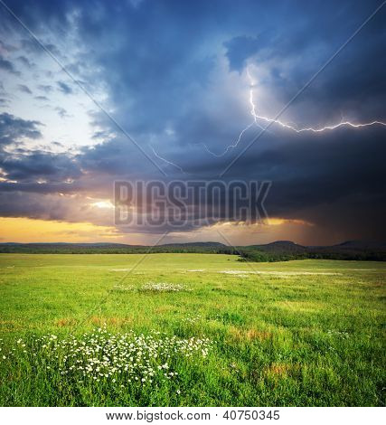 Prato in montagna. Nube di pioggia e fulmini. Composizione di natura.