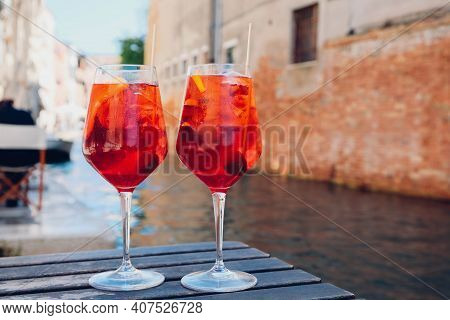 Two glasses of Spritz Veneziano cocktail served near the Venetian canal.  Popular italian summer ape