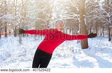 Outdoor Functional Strength Training Concept. Senior Athletic Man Stretching His Arm Muscles With Re