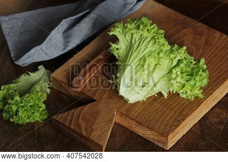 Healthy Eating Concept. Raw Green Organic Lettuce Ready To Chop On Cutting Board With Knife