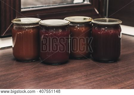 Various Marmalade In Glass Jars In The Kitchen, A Row Of Glass Jars With Peach, Raspberry, Acbricot 