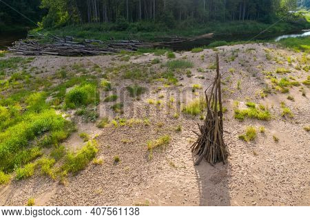 Woodpile Of Dry Branches On The Shore Of The River Before Burning For A Huge Fire. Midsummer Celebra