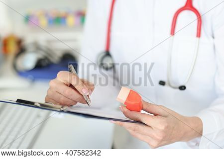 Pulmonologist Holding Inhaler In Hands And Writing In Documents Closeup. Bronchial Asthma Treatment 