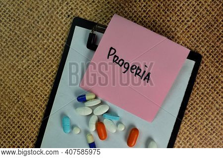 Progeria Write On Sticky Notes Isolated On Wooden Table.