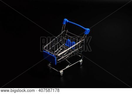 Small Blue Shopping Cart On A Black Background. Copspace