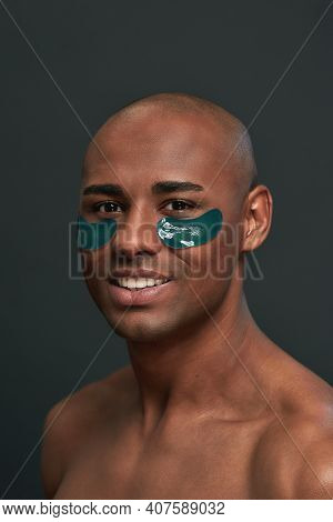 Male With A Fit Body Complection Giving A Smile While Having Face Beauty Patches Below The Eyes