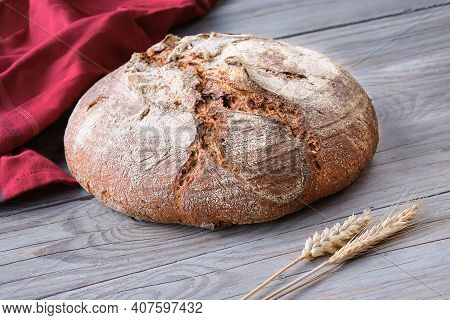 No Knead Handmade Loaf On Cutting Board On Wood With Linen Towel, Spelt Ears. German Bauernbrot Mean