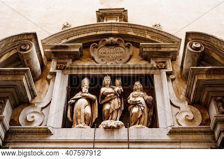 Temple Of Santa Grata, Bergamo. High Relief On The Facade With Figures Of Women, An Old Man And A Ba