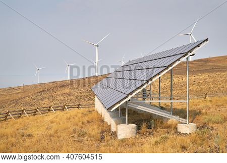Wind Turbines And Solar Panel. Wind Turbines And Solar Panels On An Arrid Field Of Grass In Washingt