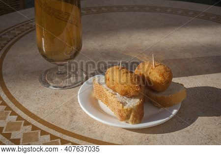 Spanish Pinchos Of Croquettes Close To Glass Of Beer. Pincho Served Over Sunny Terrace Table