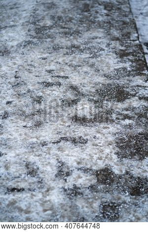 De-icing Chemicals On The Pavement. Pavement Is Sprinkled With Technical Salt Or Salt Mixtures Based