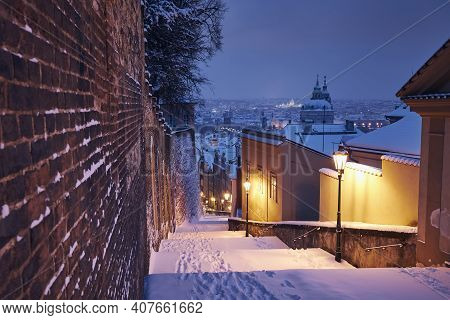Cityscape Of Prague In Winter. Illuminated Historical Staircase Against Lesser Town And Old Town Ear