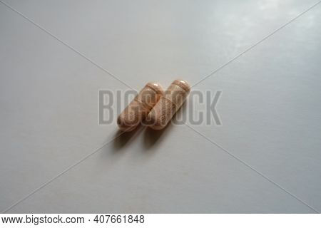 Identical Two Pink Capsules Of Probiotic Dietary Supplement