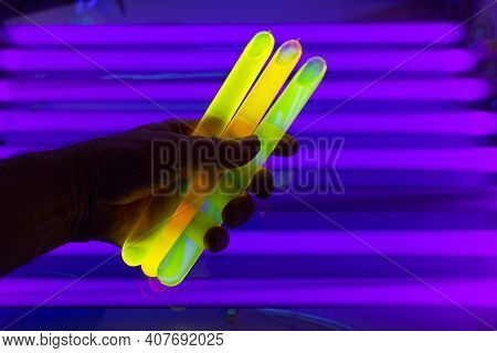 Fluorescein Glowing In Flask Under Ultraviolet Light. A Closeup Of Man Hand Holding Up A Vial  Fluor