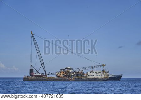 Puerto Ayora, Galapagos Islands, Ecuador - 03 03 2019, Old Industrial Vessel With Huge Cranes Lying 