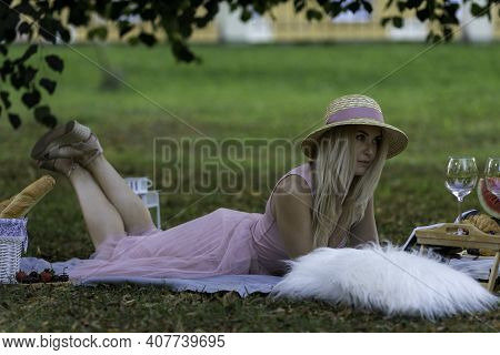 Young Woman Having A Picnik Outdoor In A Park