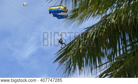 Airlie Beach, Queensland, Australia - February 2021: Tandem Skydivers With Parachute Open Coming Int