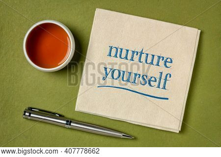 nurture yourself - inspirational handwriting on a napkin with a cup of tea, self care concept