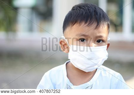 Asia Boy Wearing Facial Mask For Protect Corona Virus And Air Pollution Pm2.5 With Blurred Backgroun