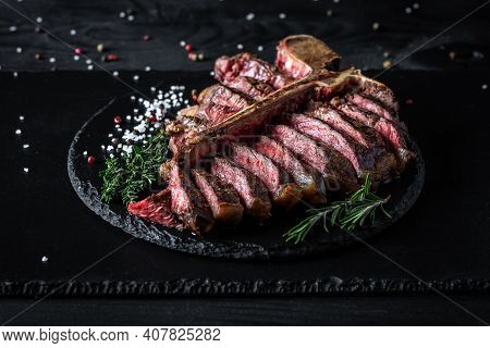 Barbecue Wagu T-bone Steak. Porterhouse Grilled Beef Steak Medium Rare With Spices On A Black Table,