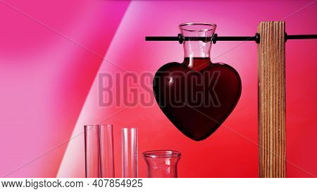 Valentines Day Potion. Love Potion In The Shape Of A Heart On A Pink Background. Chemical Flasks.