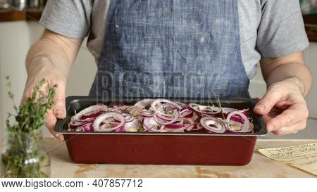 Man Without Face In Kitchen In Apron Bakes Onion Bread With Spices And Herbs In Baking Dish, Home Ba