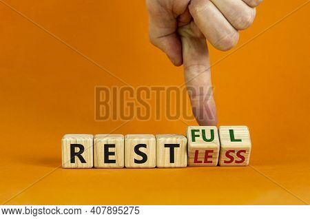 Restless Or Restful Symbol. Businessman Turns Wooden Cubes, Changes The Word 'restless' To 'restful'
