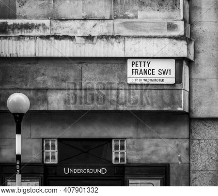 Westminster Skyline At Sunset, London, Ukpetty France And Underground Street Signs With A Belisha Be