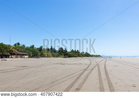 Panama Armuelles Beach, Tire Marks On The Sand. Panoramic View On A Sunny Day Of The Coastline