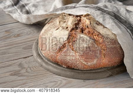 No Knead Handmade Loaf On Cutting Board On Wood With Linen Towel, Spelt Ears. German Bauernbrot Mean
