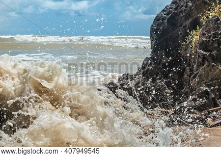 Wave Hitting Dark Stone On African Beach In Axim Ghana