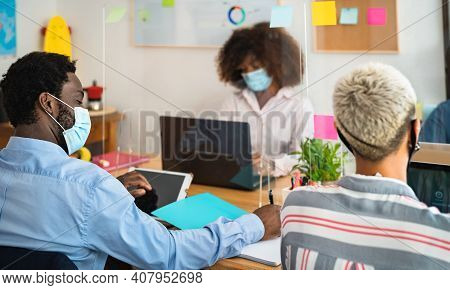 Young People In Co-working Creative Space Wearing Surgical Mask And Keeping Social Distance To Avoid