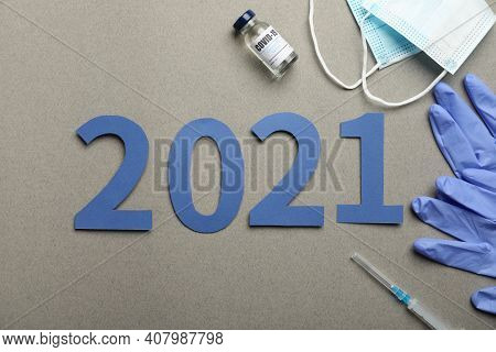 Flat Lay Composition With Coronavirus Vaccine And Number 2021 On Grey Background